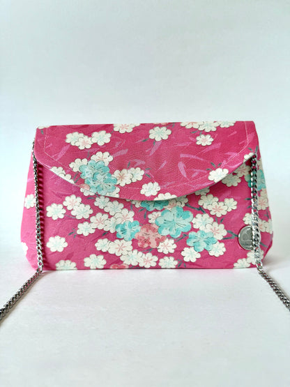 Pink kimono silk clutch bag featuring multi colored cherry blossoms and silver colored chain strap