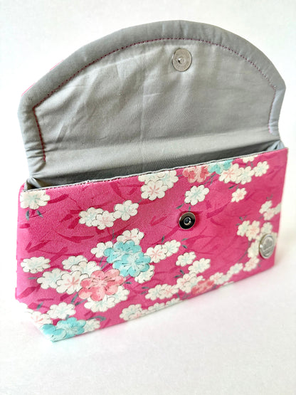 Hand stitched seam on pink kimono silk clutch bag with blue, white, and pink cherry blossoms and silver cotton interior