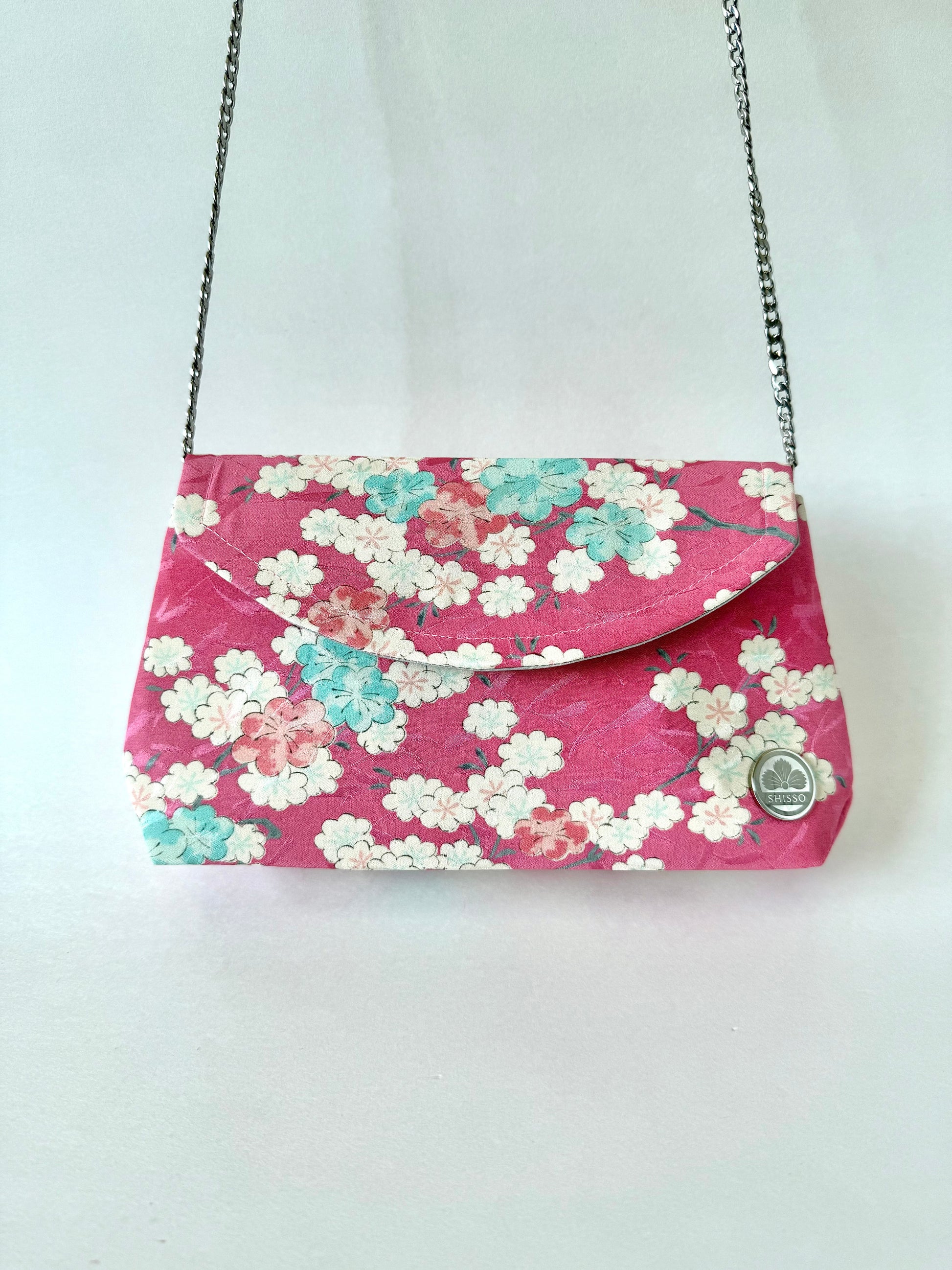 Handmade clutch bag made from pink kimono silk hanging from a detachable 48 inch metal chain strap