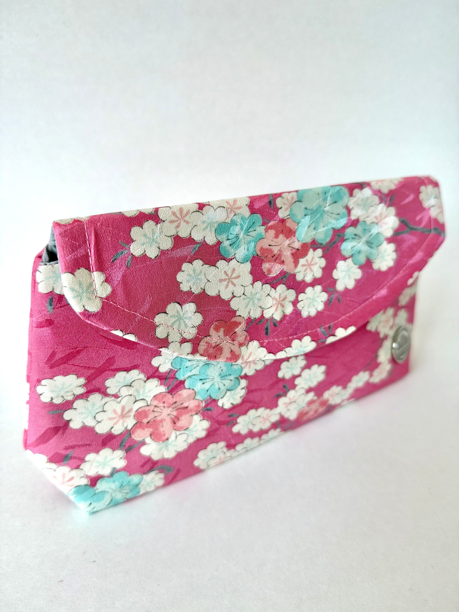 Front left side angle of handmade silk kimono clutch bag with pink top stitching