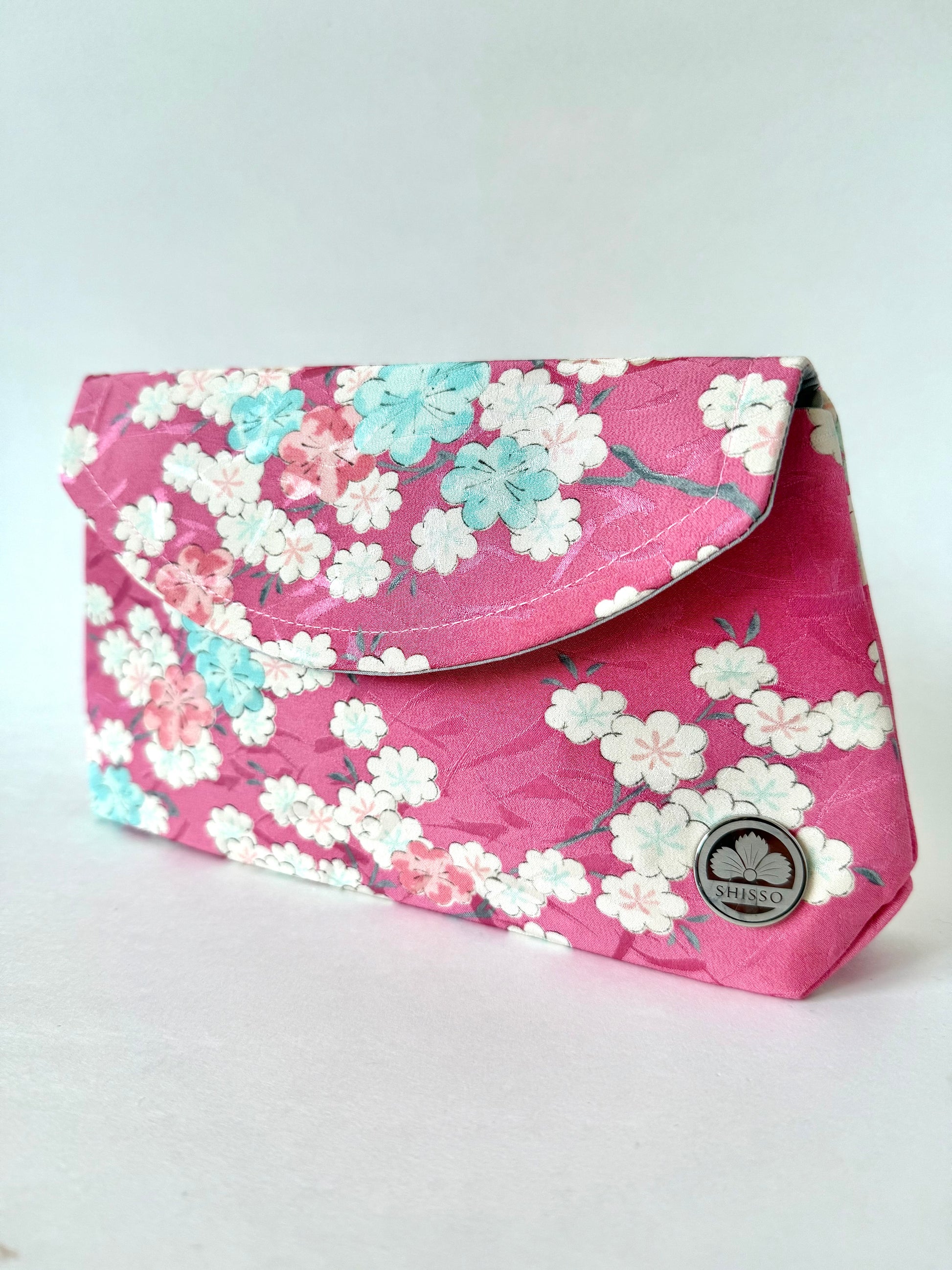 Handmade fold over clutch with pink kimono silk exterior featuring cherry blossom branches and flowers