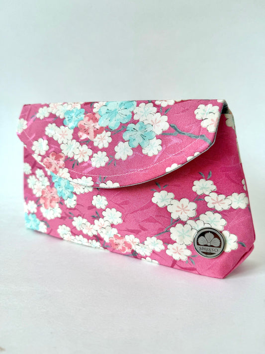 Handmade fold over clutch with pink kimono silk exterior featuring cherry blossom branches and flowers