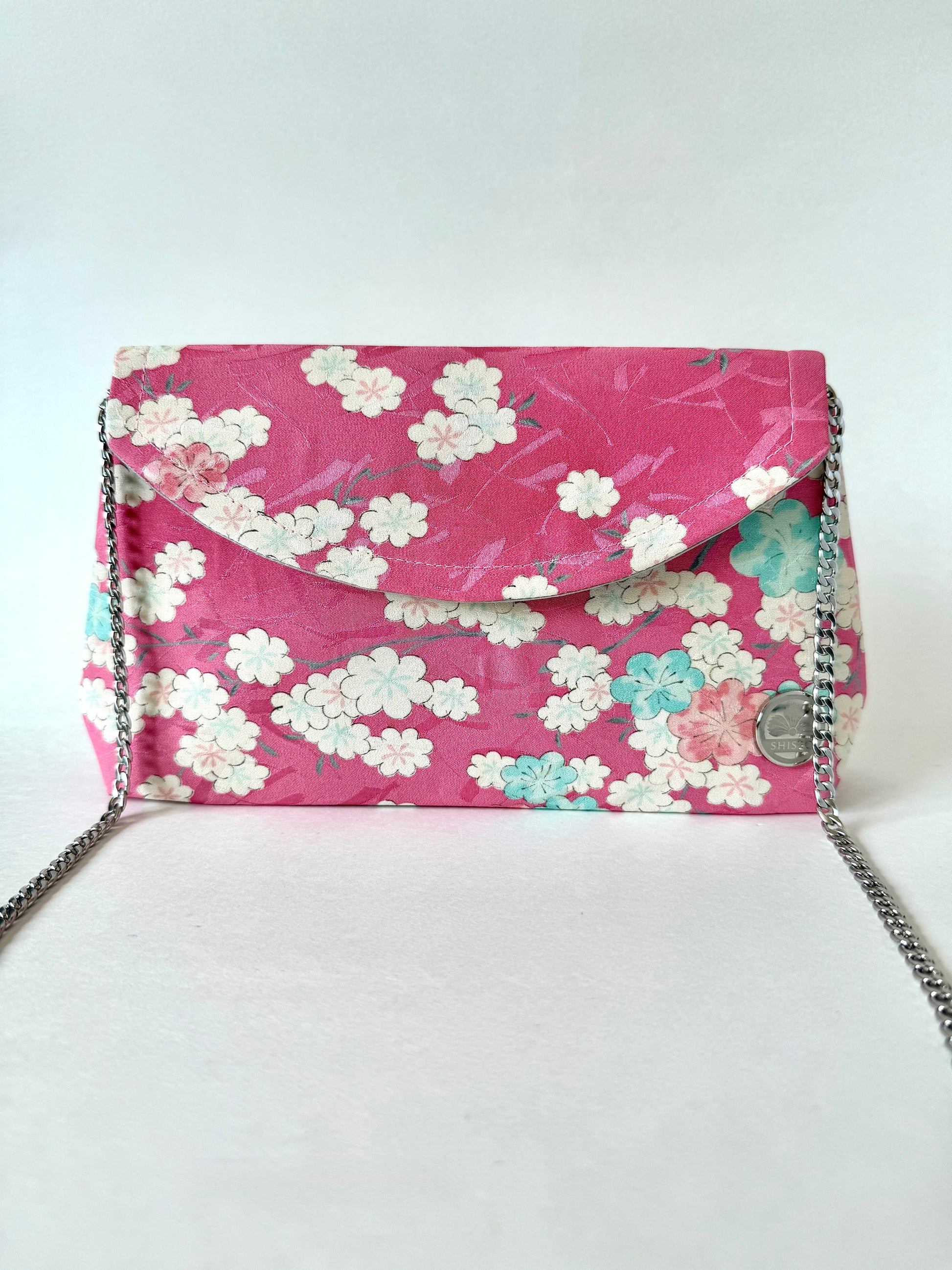 Front view of pink kimono silk clutch bag with 48” chain strap
