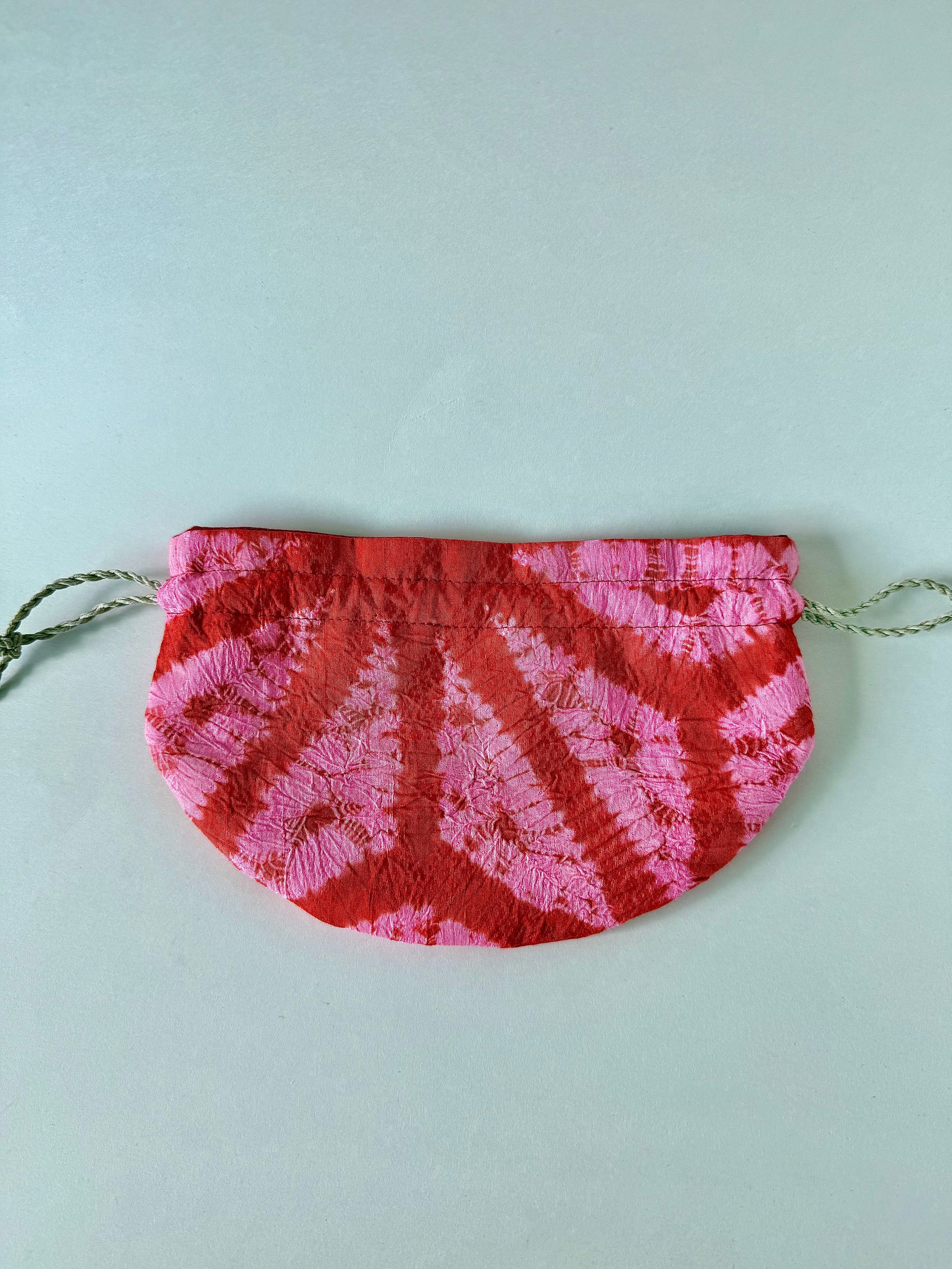 back view of flat laying red and pink shibori silk drawstring bag