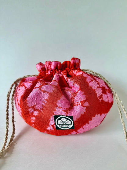 Red and pink shibori silk pouch cinched at the top with hemp drawstrings