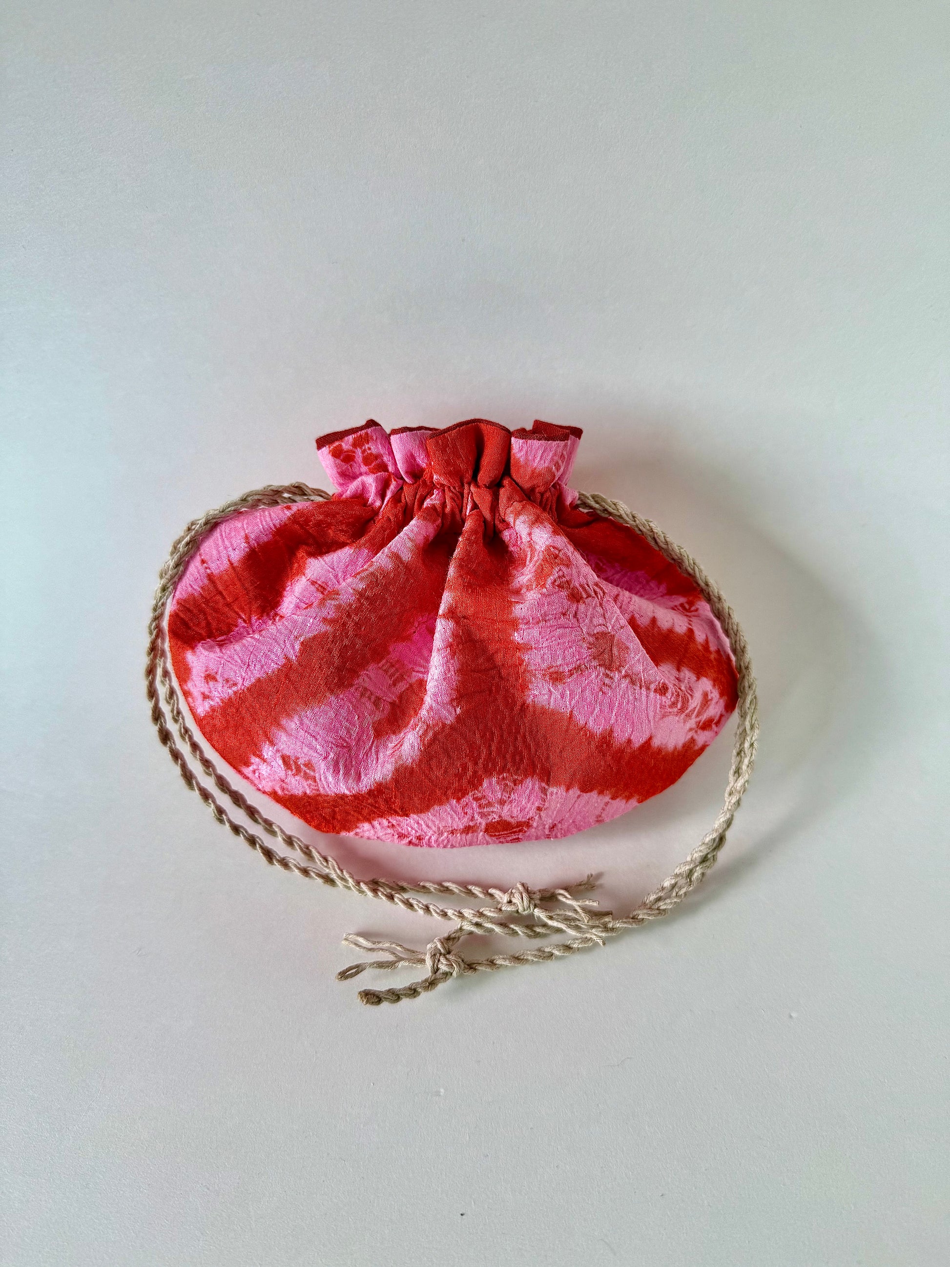 Back view of Upcycled red and pink kimono silk drawstring pouch cinched closed with natural hemp drawstrings