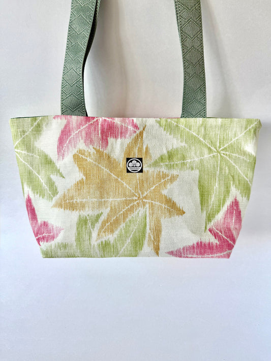 Kimono sha silk tote bag with red, yellow, and green maple leaf motif hanging from green nylon handles