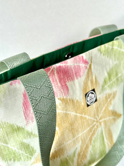 Front left view of kimono silk tote bag with green nylon handles featuring a geometrical pattern