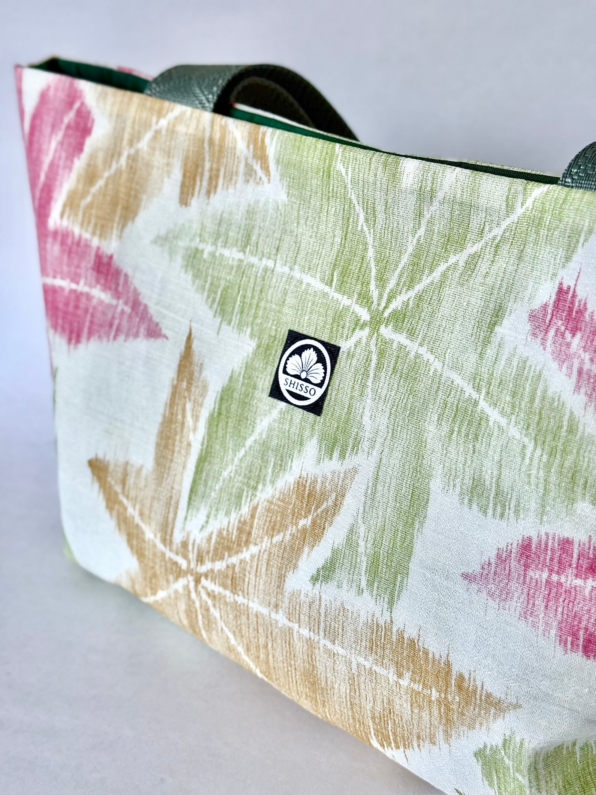 Front right angle of woven and textured kimono silk tote bag with branded tag 