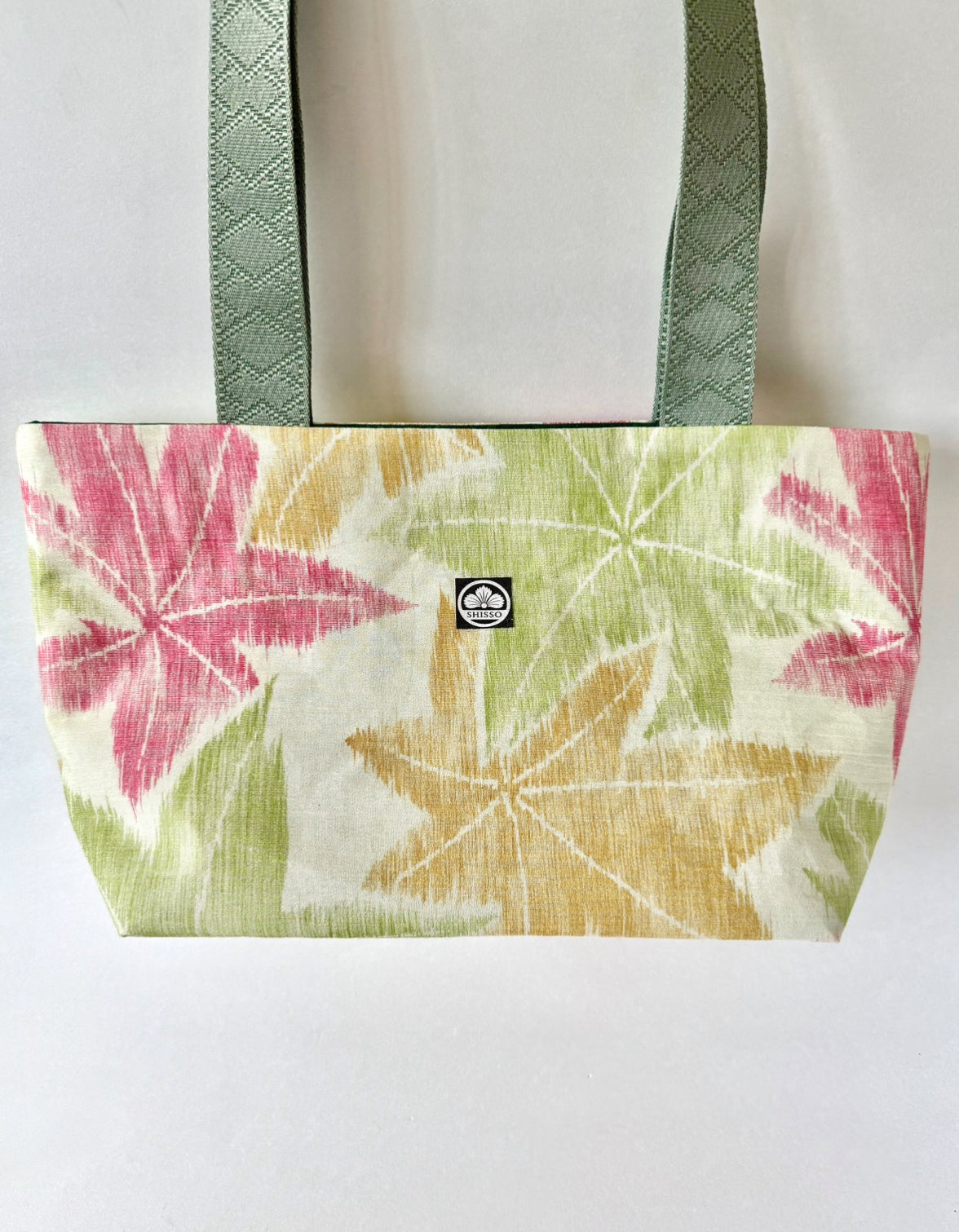 Textured woven kimono silk tote featuring Japanese maple leaf motifs in green, red, and yellow