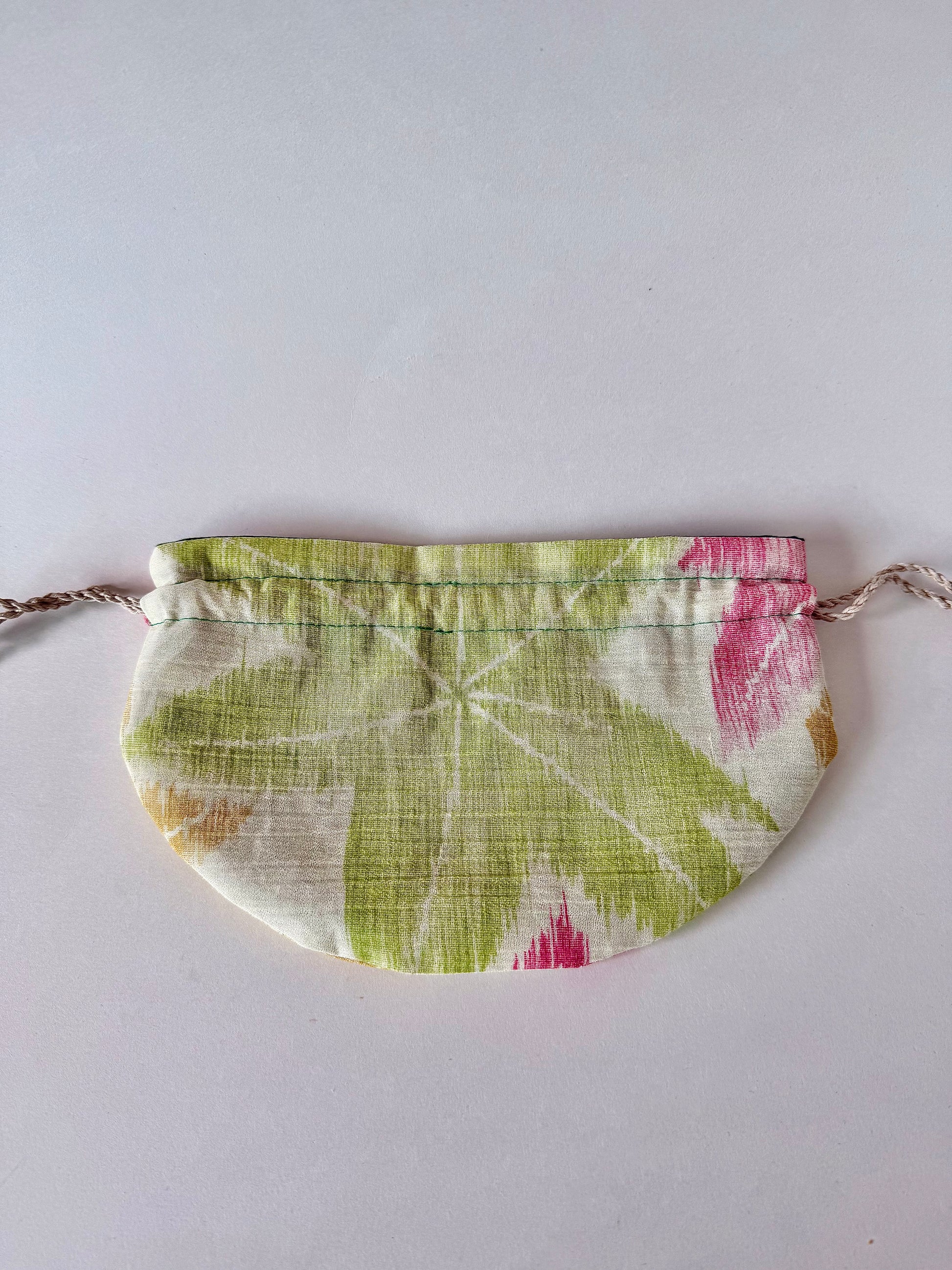 backside of flay laying off white woven kimono silk drawstring pouch with green, red, and yellow momiji pattern